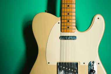 Yeşil arka planı olan klasik elektirikli gitar. Klasik müzik aletinin konsept fotoğrafı, canlı müzik.