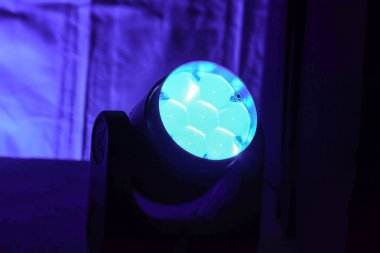 Konserde canlı yayında mavi bir sahne ışığının yakın çekimi. Tek bir sahne ışığının uzay fotoğrafçılığını kopyala.