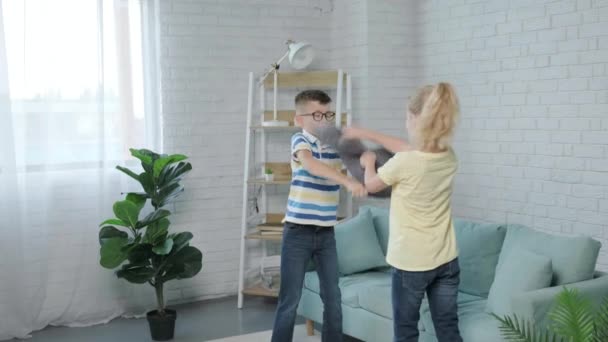幸せな双子の子供2人が枕で家で戦っています 幸せな子供時代 — ストック動画