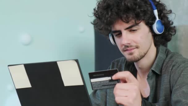 Кучеряве Волосся Молодий Чоловік Купує Онлайн Кредитною Карткою Використовуючи Смартфон — стокове відео