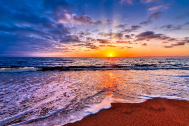 Güneşin doğuşuyla tropik bir sahil Dik Görüntü Biçiminde Ran Işınları Patlıyor