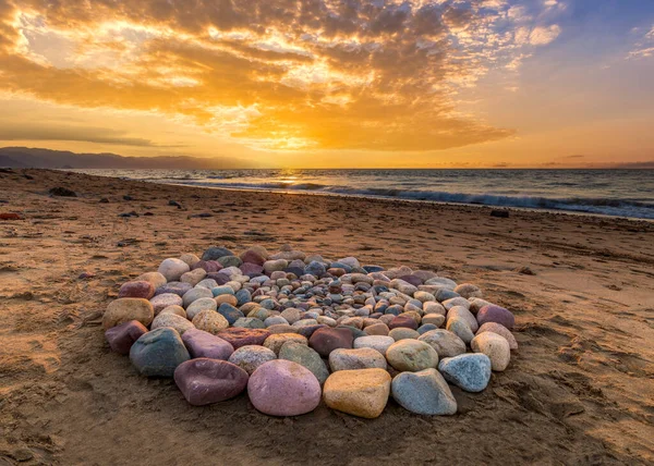 ビーチで日没時に精神的な儀式のための儀式の石がサークルに配置されています ストック写真