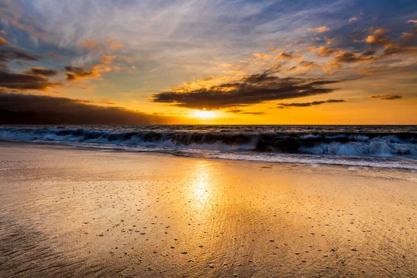 砂浜で光の反応で美しいカラフルなオレンジ色の海の夕日 ロイヤリティフリーのストック画像