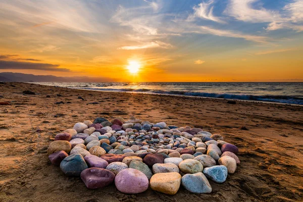 ビーチで日没の間に精神的な儀式のための神聖な儀式の石がサークルに配置されています ロイヤリティフリーのストック写真