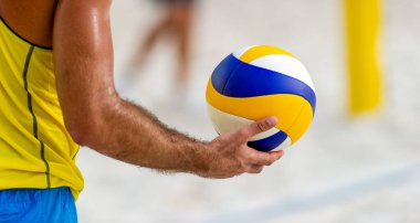 Bir voleybol oyuncusu topa servis yapmaya hazırlanıyor.
