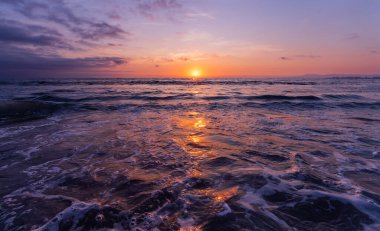 Güneş 'in yansımasıyla okyanus gün batımı sudan parıldıyor.