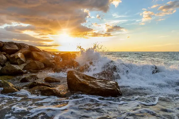 Gün batımı Okyanusu Kapanışı Renkli bir gün batımı gökyüzü ufkuyla kıyıya vuran bir dalganın