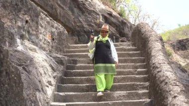 Ajanta mağaralarına kadın turist ziyareti ve antik Ajanta mağaralarını keşfetmek, Ajanta Mağaraları UNESCO 'nun Dünya Mirası Alanıdır..