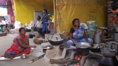 NAGPUR, MAHARASHTRA, INDIA 25 HAZİRAN 2023: İnsanlar, eski mutfağın kırsal kesimlerinde, toprak chulhas 'ta yakacak odun kullanarak taze yemek pişiriyor ve pişiriyor..
