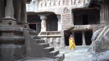 Sari ziyareti yapan Hintli kadın turist Ellora mağaralarındaki Jain mağaralarına, 5. yüzyıl ile 10. yüzyıl arasında UNESCO 'nun dünya mirası alanı arasında Jain mağarası tapınakları inşa edildi. Aurangabad, Maharashtra, Hindistan.