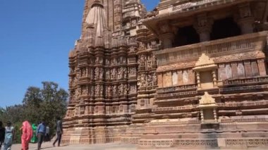 KHAJURAHO, MADHYA PRADESH, INDIA, 01 Mart 2022: Erotik mimarisi nedeniyle Khajuraho tapınağına turistik bir ziyaret, düzenli olarak pek çok ziyaretçi çekmek, UNESCO Dünya Mirası Sitesi.