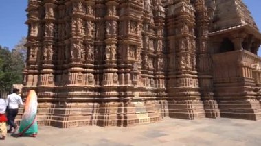 KHAJURAHO, MADHYA PRADESH, INDIA, 01 Mart 2022: Erotik mimarisi nedeniyle Khajuraho tapınağına turistik bir ziyaret, düzenli olarak pek çok ziyaretçi çekmek, UNESCO Dünya Mirası Sitesi.