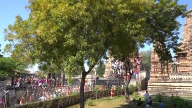 KHAJURAHO, MADHYA PRADESH, INDIA, 01 Mart 2022: Erotik mimarisi nedeniyle Khajuraho tapınağına turistik bir ziyaret, düzenli olarak pek çok ziyaretçi çekmek, UNESCO Dünya Mirası Sitesi.