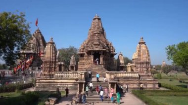 KHAJURAHO, MADHYA PRADESH, INDIA, 01 Mart 2022: Erotik mimarisi nedeniyle Khajuraho tapınağına turistik bir ziyaret, düzenli olarak pek çok ziyaretçi çekmek, UNESCO Dünya Mirası Sitesi.