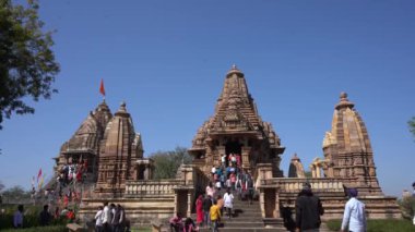KHAJURAHO, MADHYA PRADESH, INDIA, 01 Mart 2022: Erotik mimarisi nedeniyle Khajuraho tapınağına turistik bir ziyaret, düzenli olarak pek çok ziyaretçi çekmek, UNESCO Dünya Mirası Sitesi.