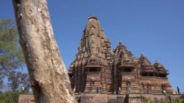 KHAJURAHO, MADHYA PRADESH, INDIA, 01 Mart 2022: Erotik mimarisi nedeniyle Khajuraho tapınağına turistik bir ziyaret, düzenli olarak pek çok ziyaretçi çekmek, UNESCO Dünya Mirası Sitesi.