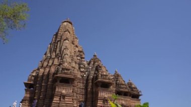 KHAJURAHO, MADHYA PRADESH, INDIA, 01 Mart 2022: Erotik mimarisi nedeniyle Khajuraho tapınağına turistik bir ziyaret, düzenli olarak pek çok ziyaretçi çekmek, UNESCO Dünya Mirası Sitesi.