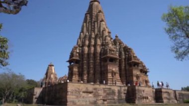 KHAJURAHO, MADHYA PRADESH, INDIA, 01 Mart 2022: Erotik mimarisi nedeniyle Khajuraho tapınağına turistik bir ziyaret, düzenli olarak pek çok ziyaretçi çekmek, UNESCO Dünya Mirası Sitesi.