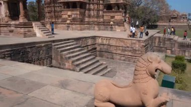 KHAJURAHO, MADHYA PRADESH, INDIA, 01 Mart 2022: Erotik mimarisi nedeniyle Khajuraho tapınağına turistik bir ziyaret, düzenli olarak pek çok ziyaretçi çekmek, UNESCO Dünya Mirası Sitesi.