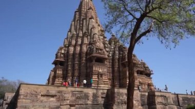 KHAJURAHO, MADHYA PRADESH, INDIA, 01 Mart 2022: Erotik mimarisi nedeniyle Khajuraho tapınağına turistik bir ziyaret, düzenli olarak pek çok ziyaretçi çekmek, UNESCO Dünya Mirası Sitesi.