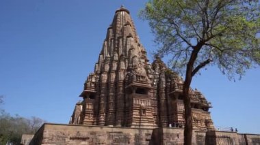 KHAJURAHO, MADHYA PRADESH, INDIA, 01 Mart 2022: Erotik mimarisi nedeniyle Khajuraho tapınağına turistik bir ziyaret, düzenli olarak pek çok ziyaretçi çekmek, UNESCO Dünya Mirası Sitesi.