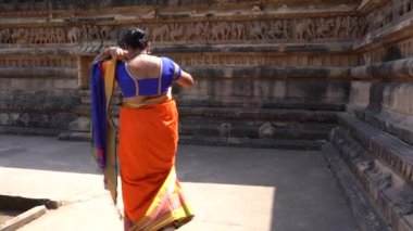 Renkli sarili kadın turist, Hindistan 'daki UNESCO Dünya Mirası Bölgesi, Khajuraho Tapınağı' nda yürüyor..