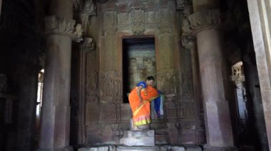 Renkli sarili kadın turist, Hindistan 'daki UNESCO Dünya Mirası Bölgesi, Khajuraho Tapınağı' nda yürüyor..