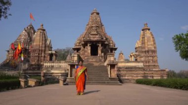 Renkli sarili kadın turist, Hindistan 'daki UNESCO Dünya Mirası Bölgesi, Khajuraho Tapınağı' nda yürüyor..