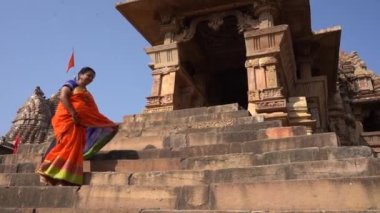 Renkli sarili kadın turist, Hindistan 'daki UNESCO Dünya Mirası Bölgesi, Khajuraho Tapınağı' nda yürüyor..