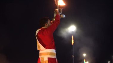 NARMADA, GUJARAT, INDIA, 17 Mart 2022: Narmada nehrine ibadet etmek için Narmada aarti adı verilen akşam ayini sırasında kutsal Narmada nehrinin kırmızı cübbeli rahipleri dua ediyorlar