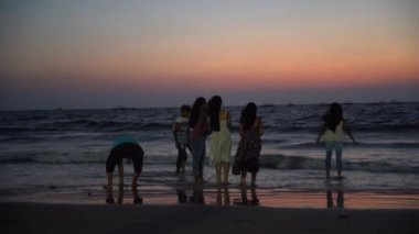 GOA, Hindistan, 18 Mart 2023: Günbatımının tadını çıkaran turist Calangute Sahili, Goa, Hindistan.