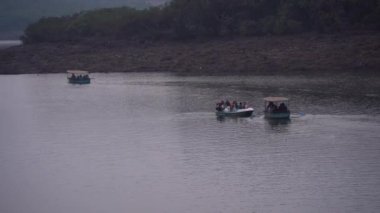 MAHABALESHWAR, MAHARASHTRA, INDIA, 15 Mart 2023: Turistler, geleneksel ahşap tekneleriyle gölün tadını çıkarıyorlar..