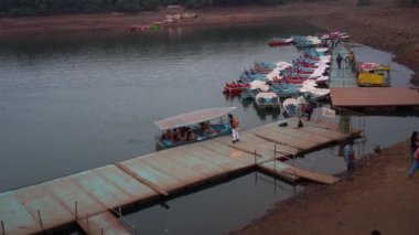 MAHABALESHWAR, MAHARASHTRA, INDIA, 15 Mart 2023: Turistler, geleneksel ahşap tekneleriyle gölün tadını çıkarıyorlar..