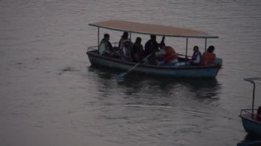 MAHABALESHWAR, MAHARASHTRA, INDIA, 15 Mart 2023: Turistler, geleneksel ahşap tekneleriyle gölün tadını çıkarıyorlar..