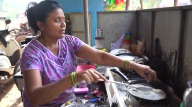 MALVAN, MAHARASHTRA, Hindistan 19 Mart 2023: Hintli kadın Gaz Fırınında kahvaltı hazırlıyor.