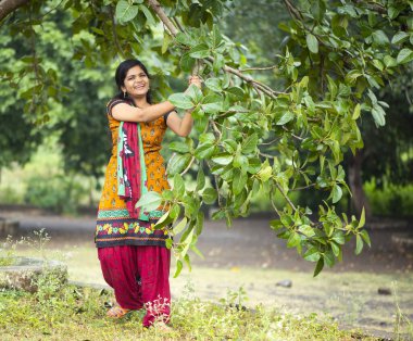 Ağaç dallarıyla dolu doğanın arasında güzel bir kız.