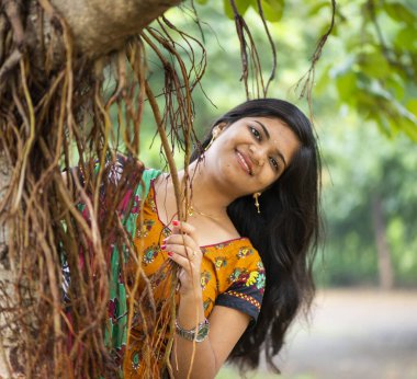 Ağaç dallarıyla dolu doğanın arasında güzel bir kız.