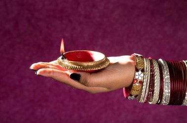 Hindistan 'daki Diwali festivalinde yanan toprak lambasını tutan kadın.