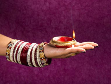 Hindistan 'daki Diwali festivalinde yanan toprak lambasını tutan kadın.