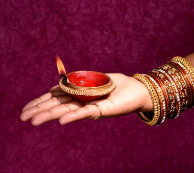 Hindistan 'daki Diwali festivalinde yanan toprak lambasını tutan kadın.