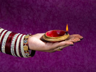 Hindistan 'daki Diwali festivalinde yanan toprak lambasını tutan kadın.
