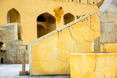 Antik astronomik gözlem evi Jantar Mantar, Jaipur, Rajasthan, Hindistan 'daki klasik sarı duvarlardaki soyut kalıplar.