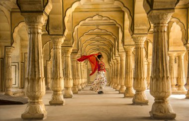 Amber Fort, Jaipur, Rajasthan, Hindistan 'daki Sütunlar Odasında dans eden genç bayan turist UNESCO Dünya Mirası Bölgesi.