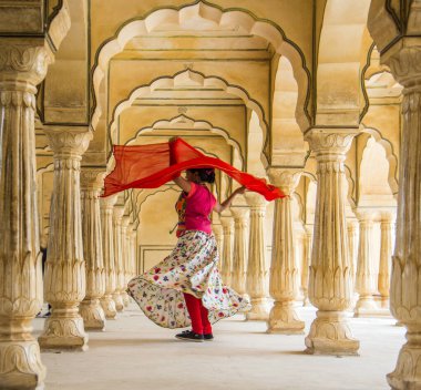 Amber Fort, Jaipur, Rajasthan, Hindistan 'daki Sütunlar Odasında dans eden genç bayan turist UNESCO Dünya Mirası Bölgesi.