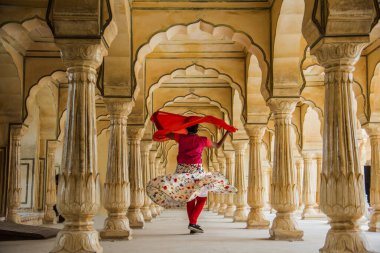 Amber Fort, Jaipur, Rajasthan, Hindistan 'daki Sütunlar Odasında dans eden genç bayan turist UNESCO Dünya Mirası Bölgesi.