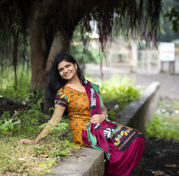 Happy Indian woman near banyan tree