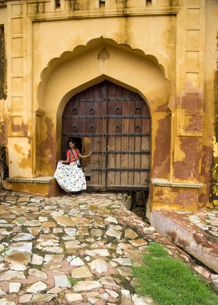 stock image Woman tourist in front of old door at Amber fort, Jaipur, India