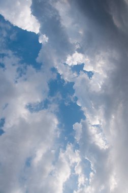 Doğal gün ışığı ve mavi gökyüzünde süzülen beyaz bulutlar