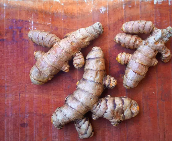 Arkaplanda taze zerdeçal kökleri