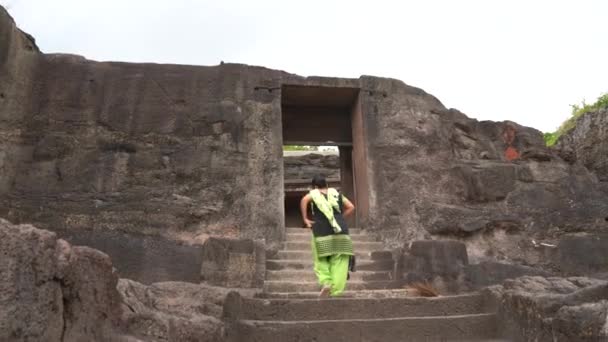 女性観光客はエローラ洞窟を探索し それは世界とユネスコの世界遺産の最大のロックカットされた洞窟の複合体の1つです — ストック動画